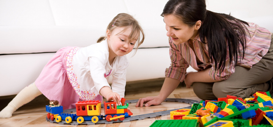 Toddler plays with train on floor